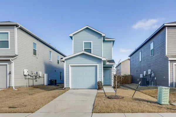 a view of a house with a yard and large tree