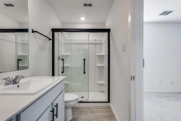 a bathroom with a sink a toilet and shower