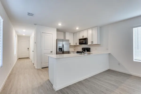 a kitchen with stainless steel appliances a refrigerator sink and microwave