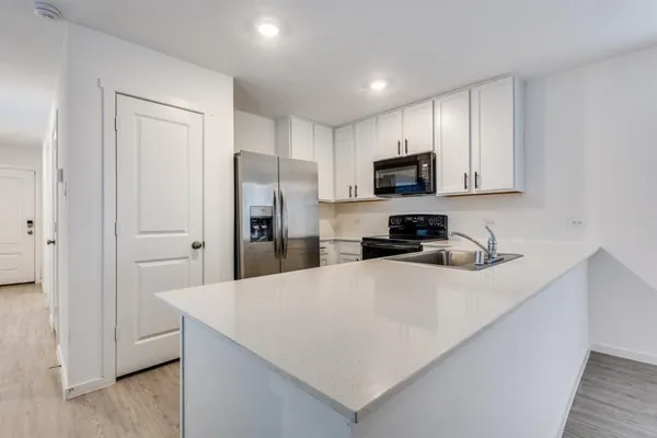 a kitchen with stainless steel appliances a refrigerator sink and microwave