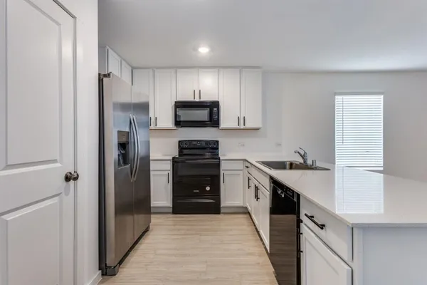 a kitchen with stainless steel appliances a refrigerator sink and cabinets