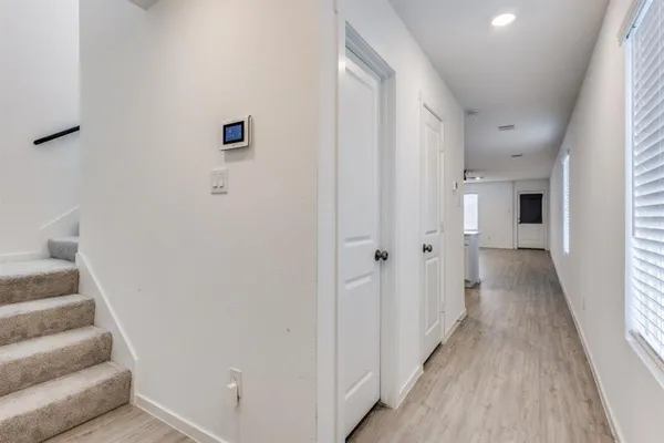 a view of a hallway with wooden floor and staircase