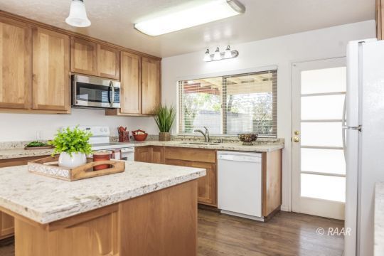 437 Peg Street Ridgecrest, CA 93555 - Photo 9 of 35 a kitchen with granite countertop a sink cabinets and wooden floor
