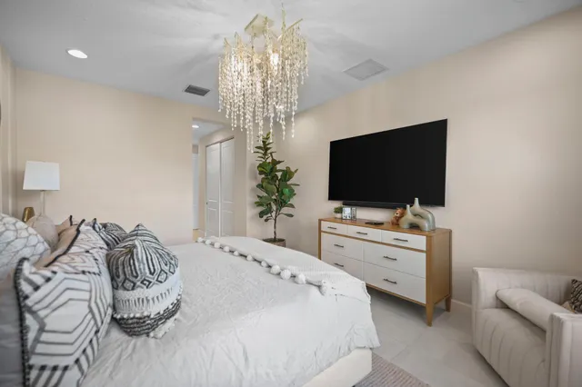 a bedroom with a bed mirror and window