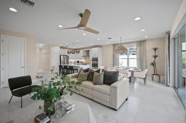 a living room with furniture potted plant floor to ceiling window and a potted plant