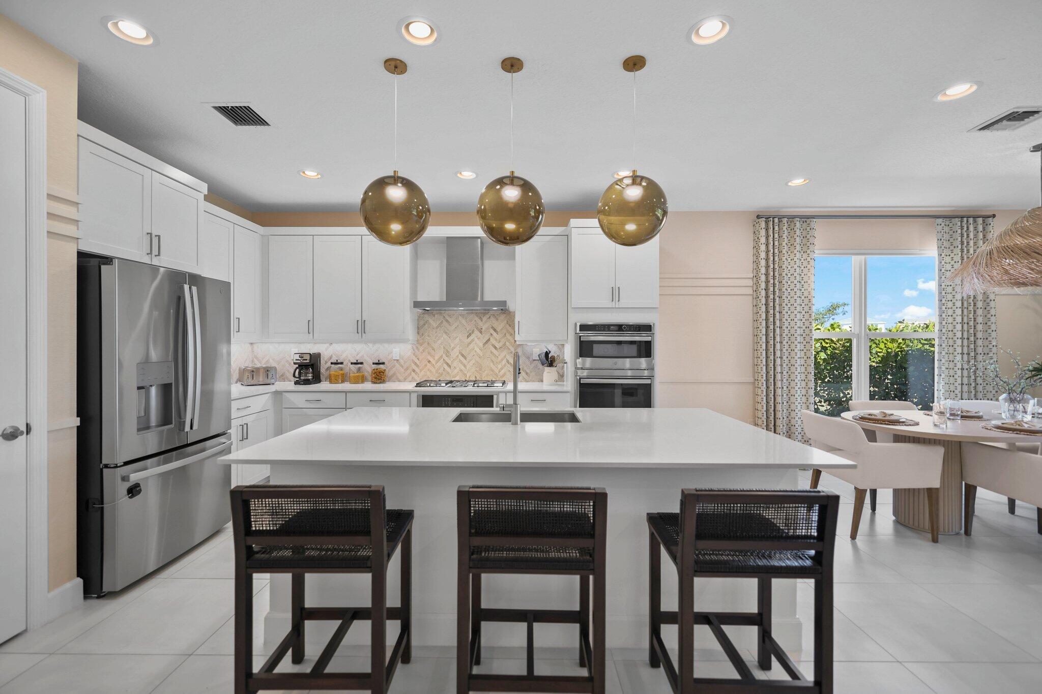 19545 Broad Shore Walk Loxahatchee, FL 33470 - Photo 33 of 65 a kitchen with stainless steel appliances granite countertop a table chairs stove and refrigerator