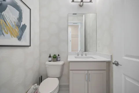 a bathroom with a toilet sink and mirror