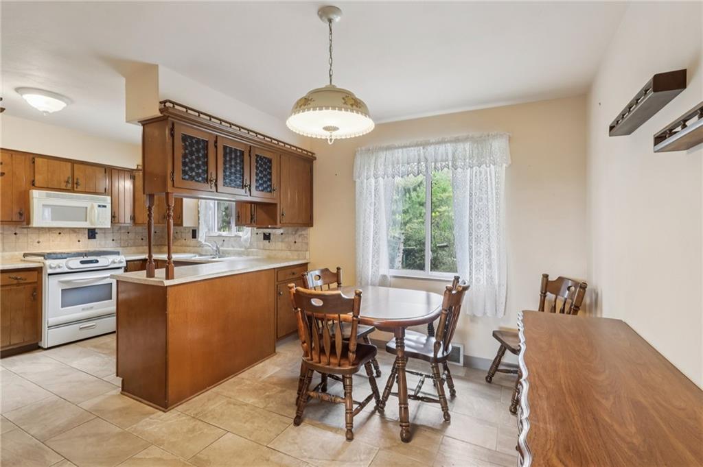 957 Cherry Lane Road Apollo, PA 15613 - Photo 13 of 38 a kitchen with stainless steel appliances granite countertop a stove top oven a sink a dining table and chairs with wooden floor