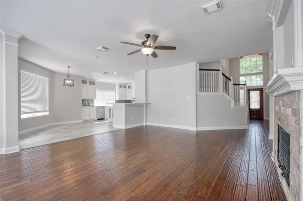 a view of empty room with wooden floor and fireplace