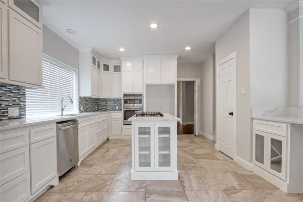 a kitchen with a stove sink and cabinets