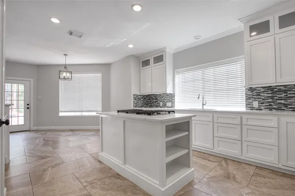 a kitchen with a stove and white cabinets