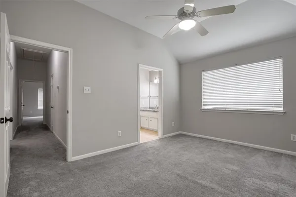 a view of an empty room with a ceiling fan and a window