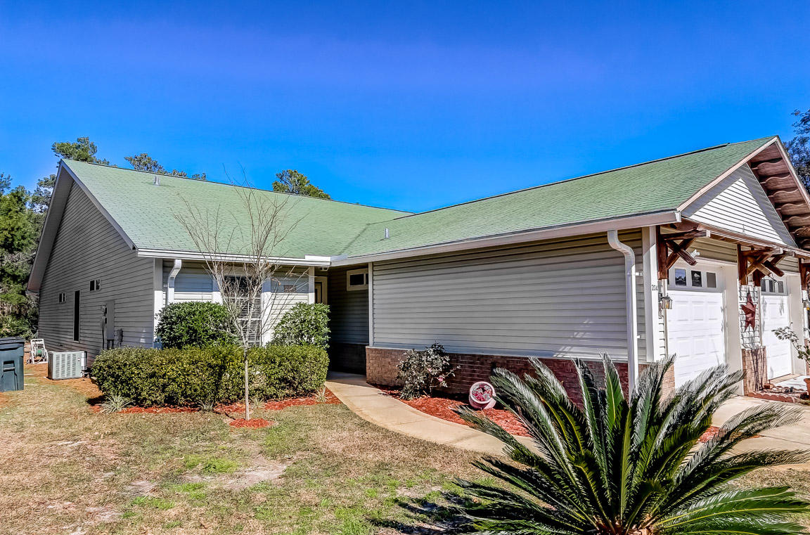 a backyard of a house with potted plants and large tree