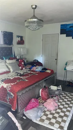 a bedroom with a bed and a chandelier