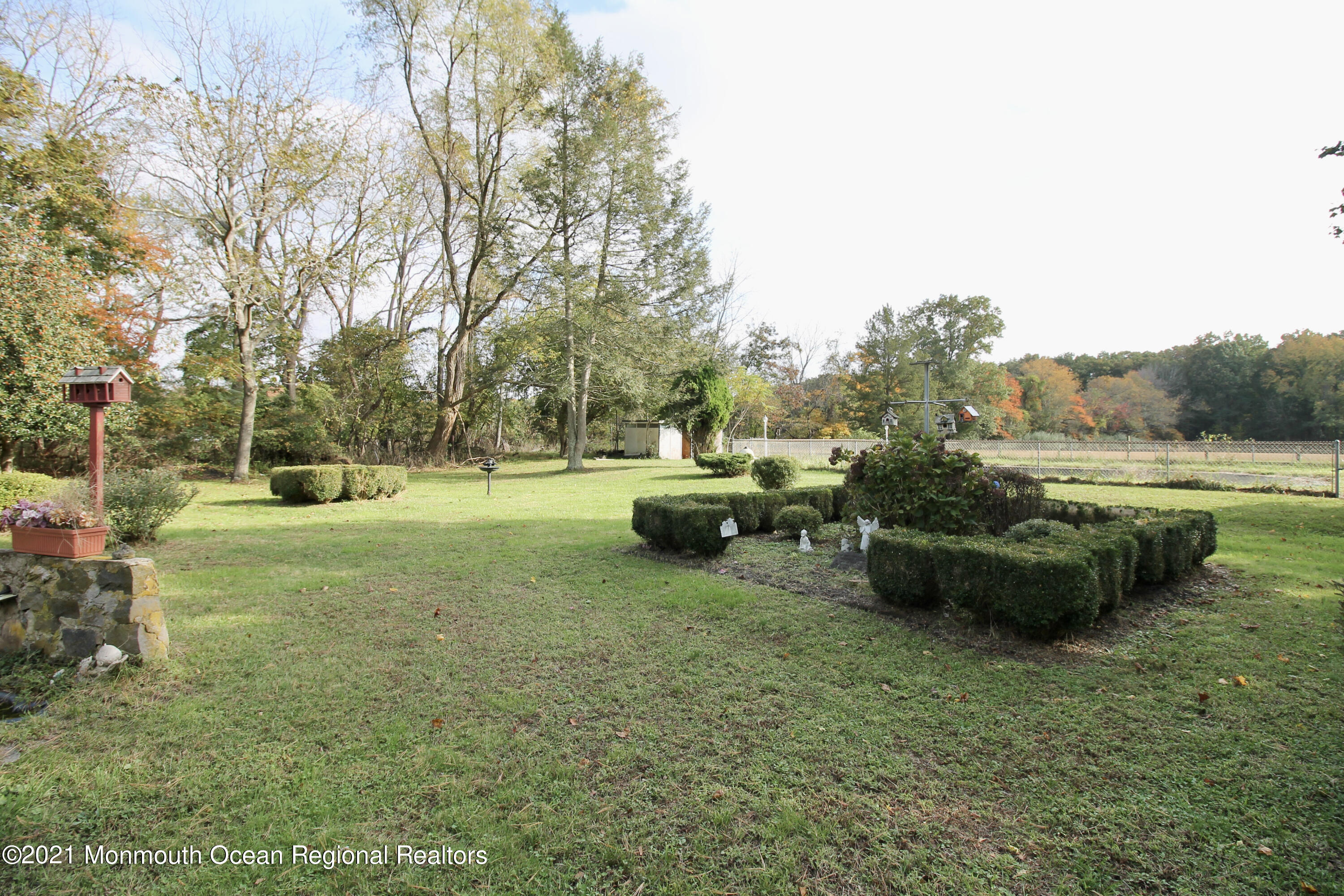 195 Bennett Road Freehold, NJ 07728 - Photo 46 of 90 a view of a garden with lawn chairs and a large tree