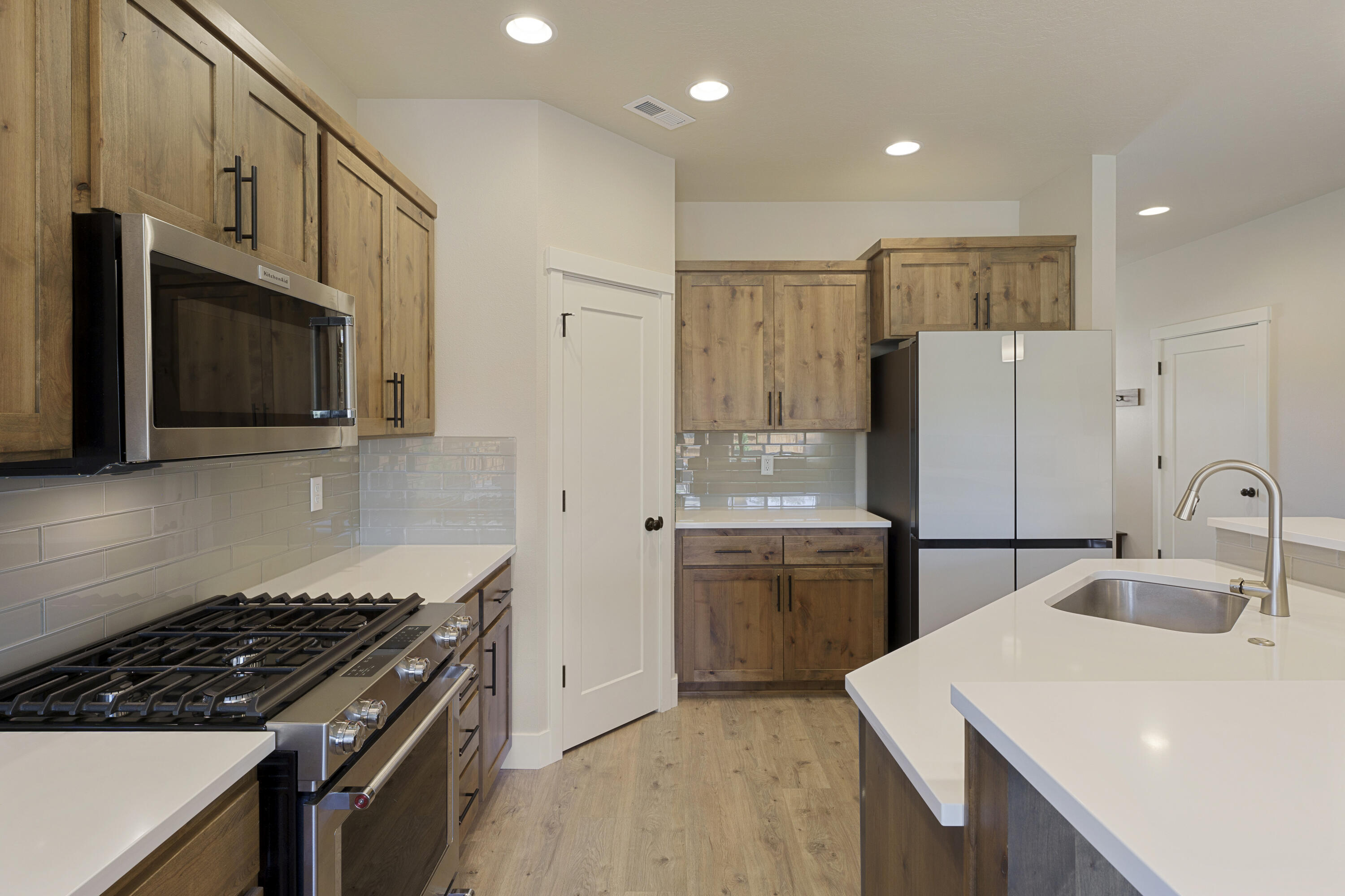 4999 Southwest Yew Place Redmond, OR 97756 - Photo 12 of 50 a kitchen with a sink stainless steel appliances and cabinets