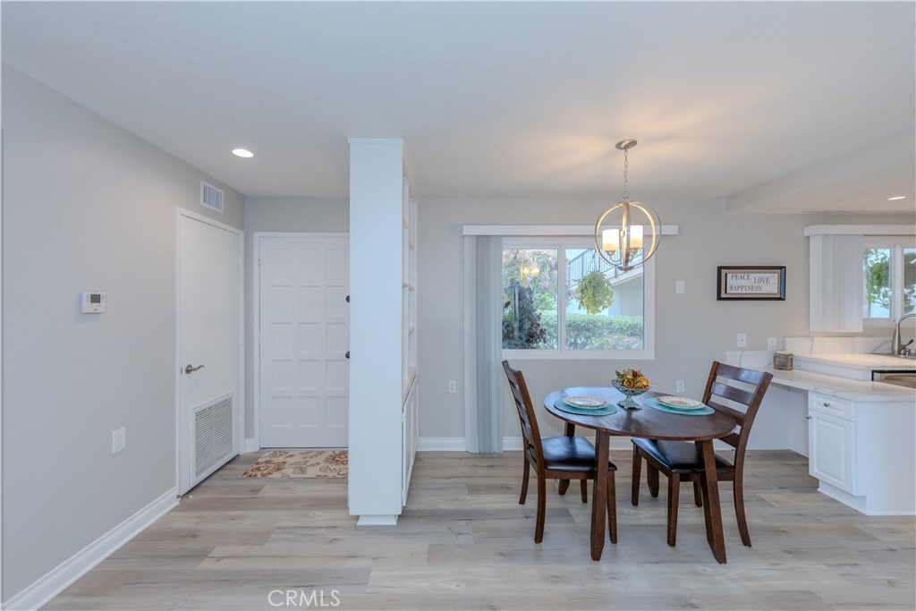 3379 Punta Alta, Unit B Laguna Woods, CA 92637 - Photo 3 of 25 a view of a dining room with furniture a chandelier and wooden floor
