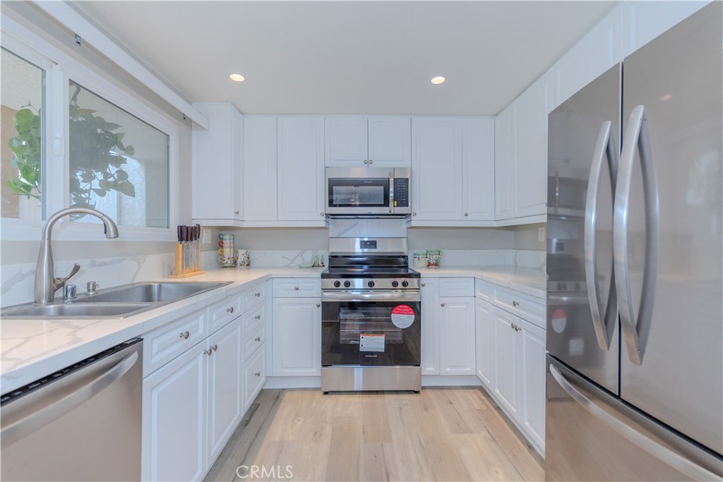 3379 Punta Alta, Unit B Laguna Woods, CA 92637 - Photo 5 of 25 a kitchen with stainless steel appliances granite countertop a stove a sink and a refrigerator