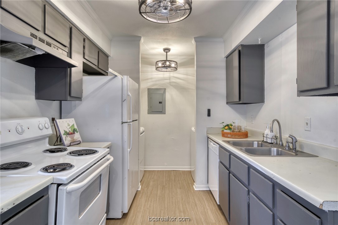 2807 Sprucewood Street, Unit A Bryan, TX 77801 - Photo 7 of 13 Kitchen featuring white appliances, crown molding, under cabinet range hood, light wood-type flooring, and electric panel