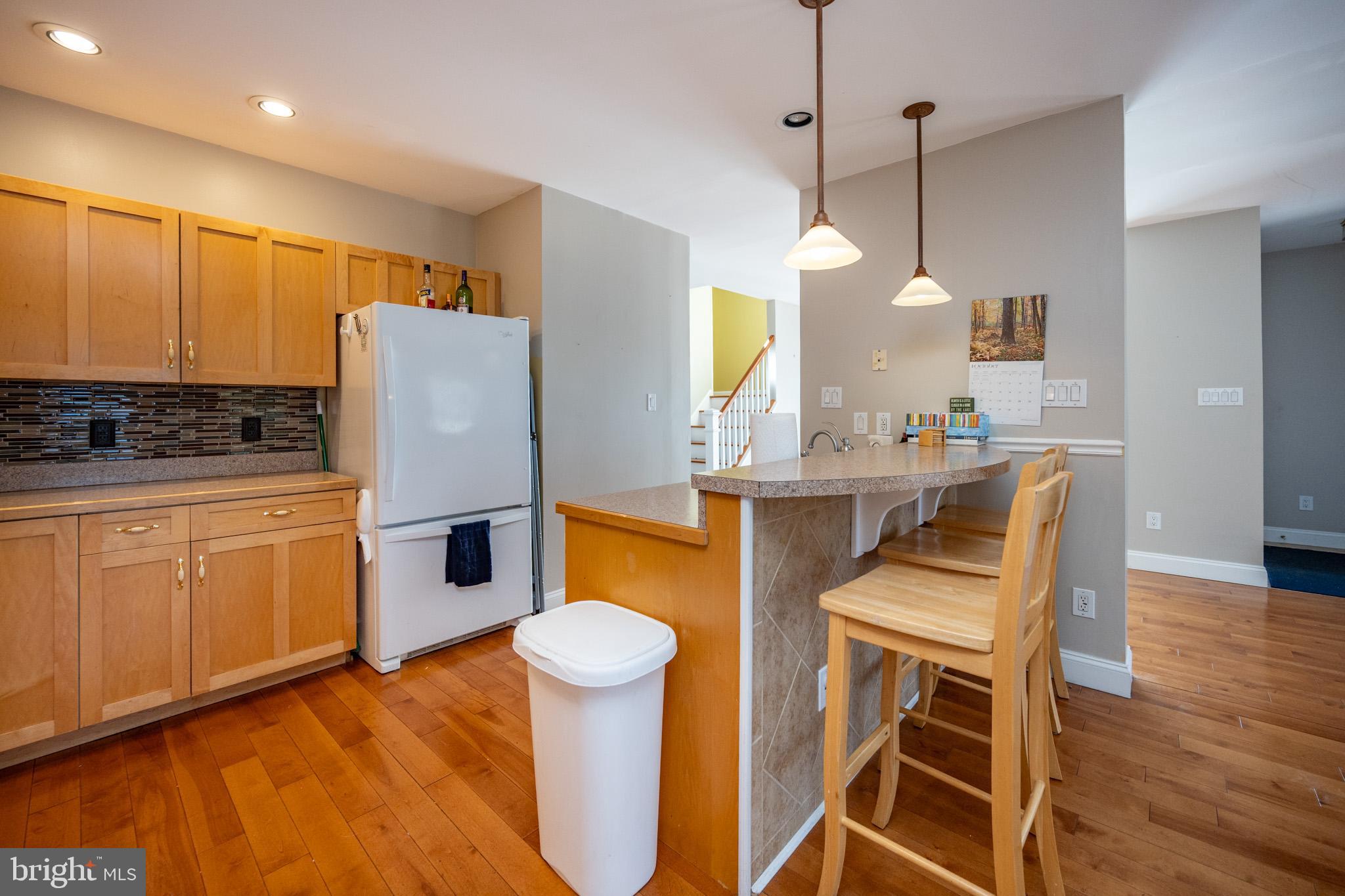 32 Hazelhurst Lane Swanton, MD 21561 - Photo 16 of 73 a kitchen with stainless steel appliances a stove a refrigerator a sink a dining table and chairs with wooden floor