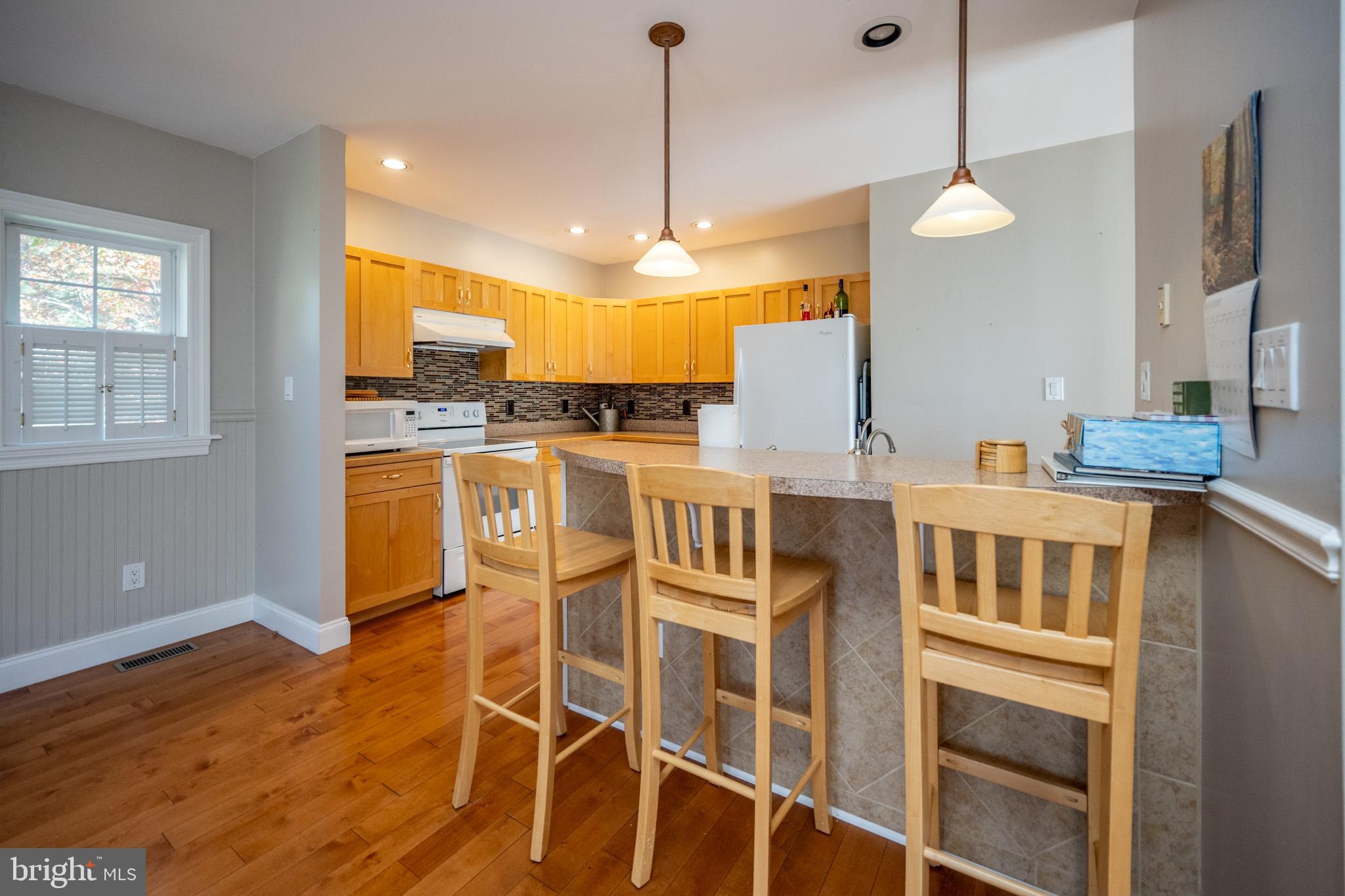 32 Hazelhurst Lane Swanton, MD 21561 - Photo 4 of 73 a kitchen with stainless steel appliances kitchen island granite countertop a stove a refrigerator a sink a dining table and chairs with wooden floor