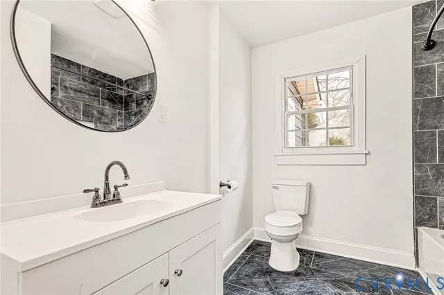 a bathroom with a toilet a sink and mirror