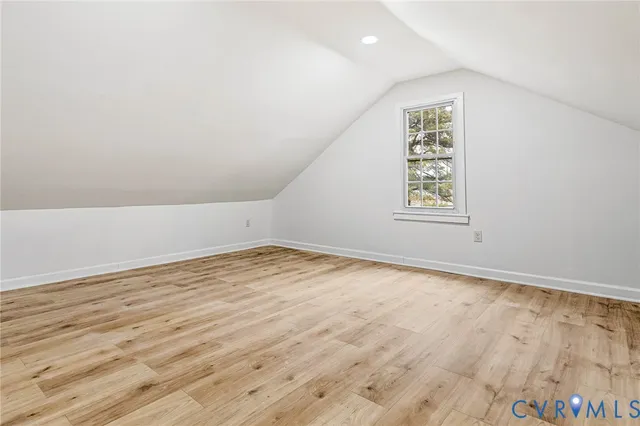 an empty room with wooden floor and window