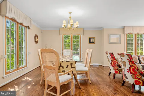 a dining room with furniture a chandelier and wooden floor