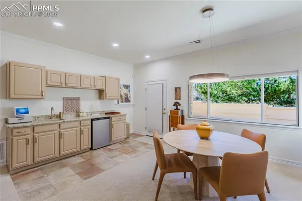 a kitchen with stainless steel appliances a table and chairs in it