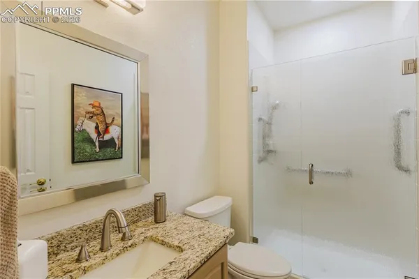 a bathroom with a granite countertop sink toilet and shower