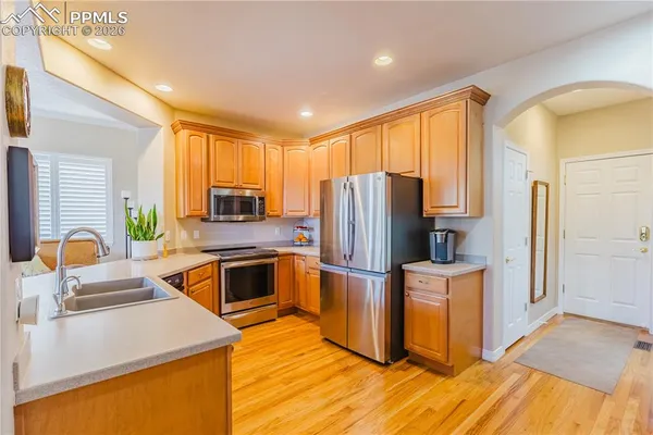 a kitchen with stainless steel appliances granite countertop a refrigerator a stove top oven a sink and dishwasher