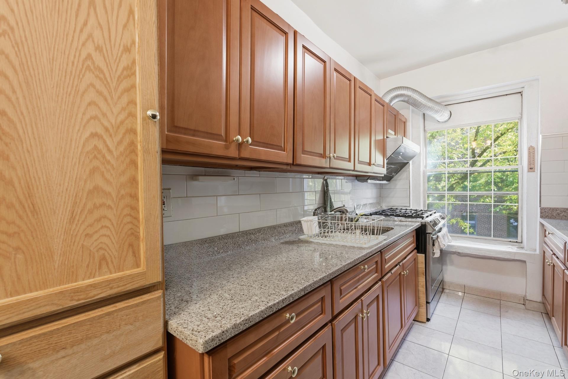 88-11 Elmhurst Avenue, Unit B6 Queens, NY 11373 - Photo 11 of 15 a kitchen with a sink stove and cabinets