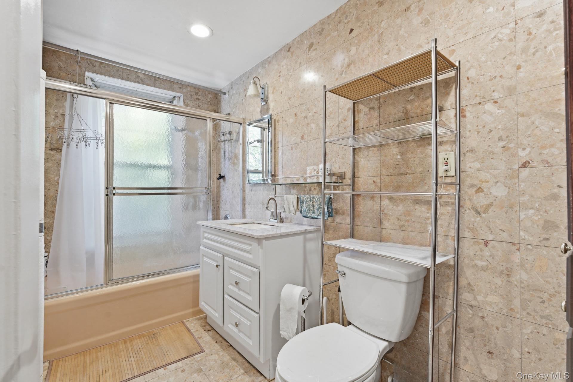88-11 Elmhurst Avenue, Unit B6 Queens, NY 11373 - Photo 13 of 15 a bathroom with a granite countertop sink toilet and shower