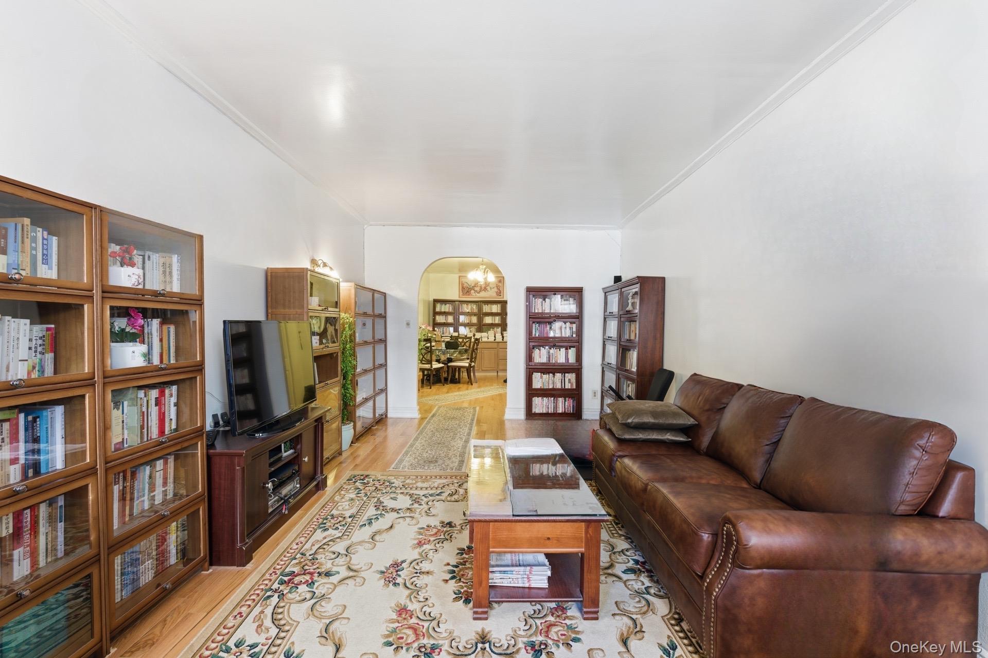 88-11 Elmhurst Avenue, Unit B6 Queens, NY 11373 - Photo 5 of 15 a living room with furniture and a book shelf