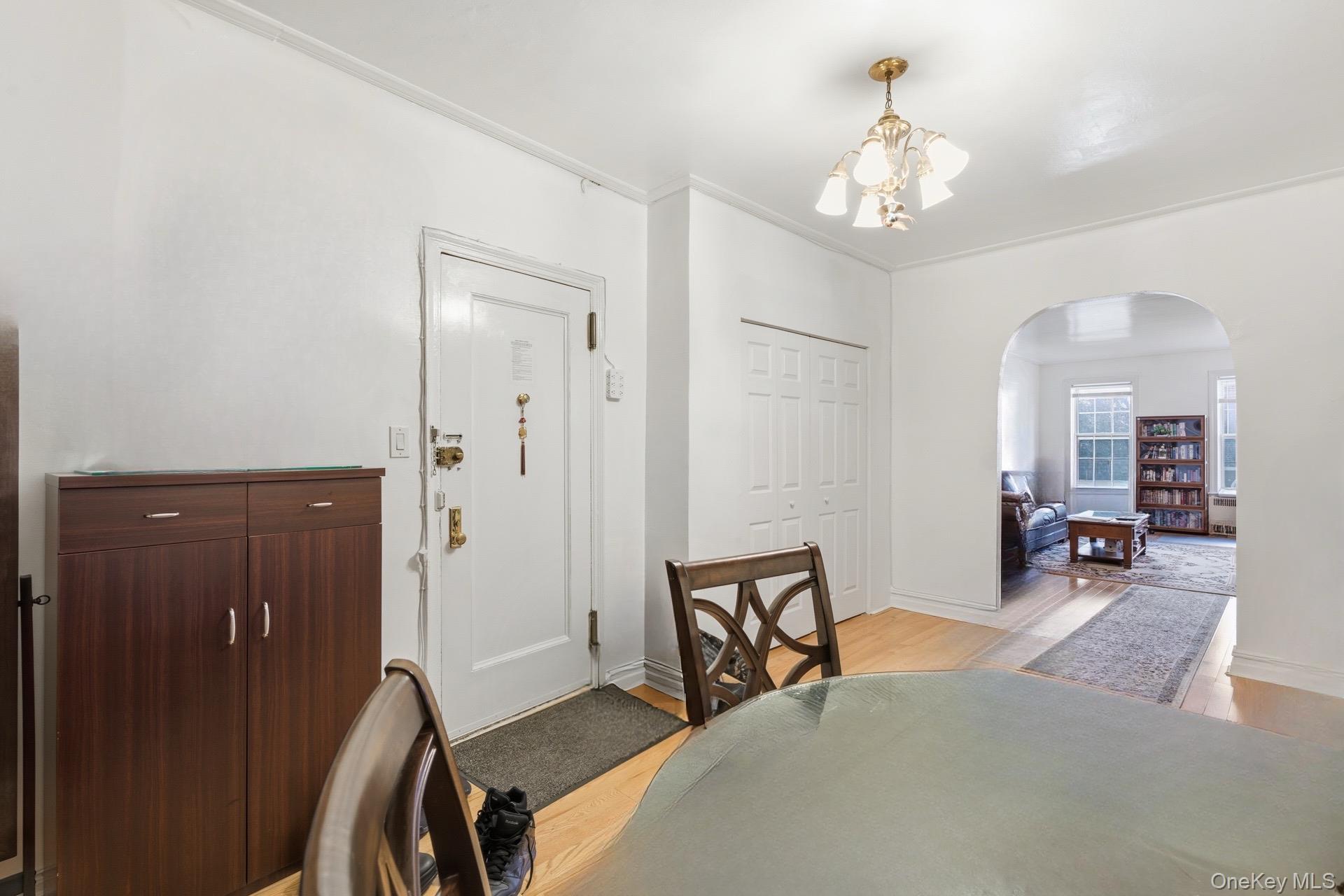 88-11 Elmhurst Avenue, Unit B6 Queens, NY 11373 - Photo 7 of 15 a bedroom with furniture and a chandelier