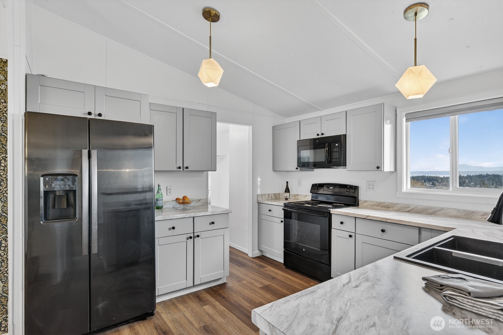 63 North Cross Island Road Camano Island, WA 98282 - Photo 12 of 23 a kitchen with stainless steel appliances granite countertop a sink a stove a refrigerator cabinets and a window