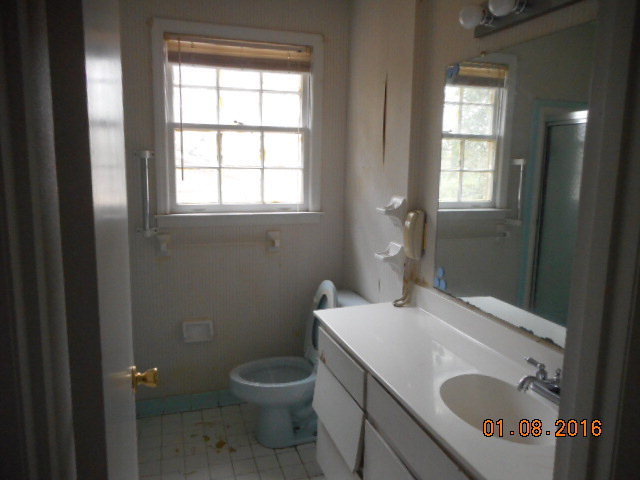 4602 Bishop Road Macon, GA 31206 - Photo 8 of 11 a bathroom with a granite countertop sink a toilet and a mirror