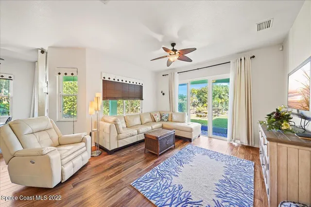 a dining room with furniture a chandelier and wooden floor
