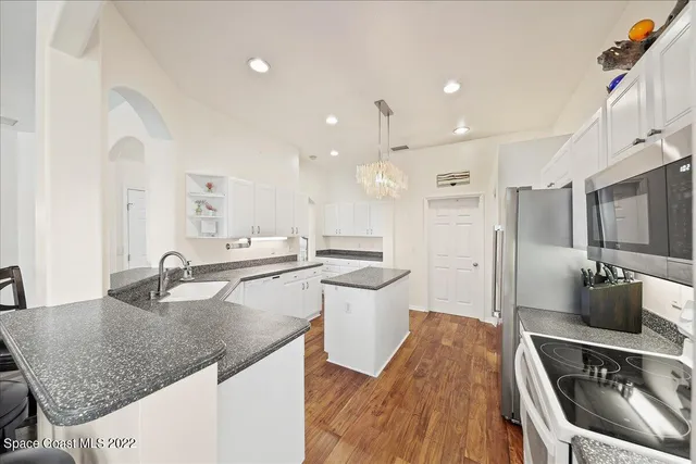 a kitchen with stainless steel appliances granite countertop a sink stove and cabinets