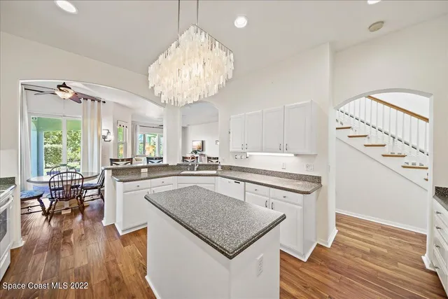 a kitchen with granite countertop white cabinets and white appliances