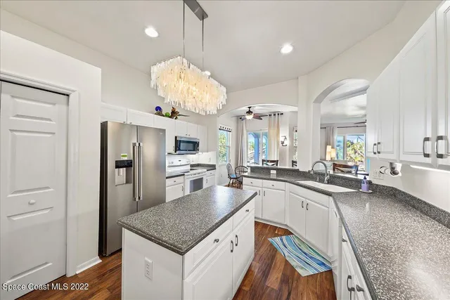 a kitchen with granite countertop a sink cabinets and wooden floor