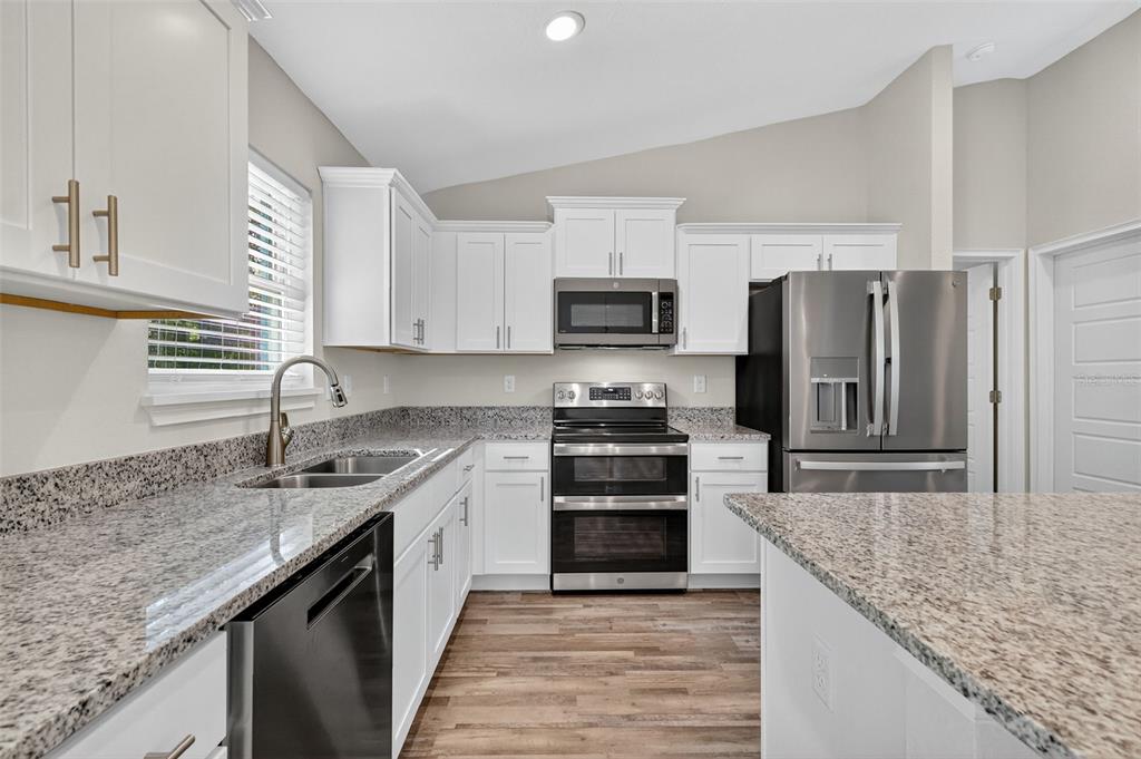 9 Chestnut Run Ocala, FL 34480 - Photo 17 of 17 a kitchen with kitchen island granite countertop a sink stove refrigerator and cabinets