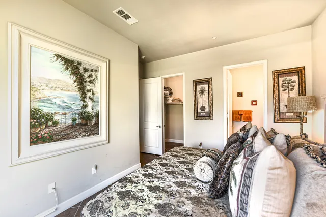 a bedroom with a bed and a painting on the wall