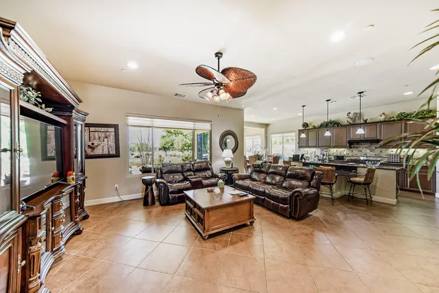 a living room with furniture a flat screen tv and kitchen view