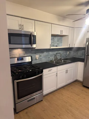 a kitchen with stainless steel appliances granite countertop a stove a sink and a microwave