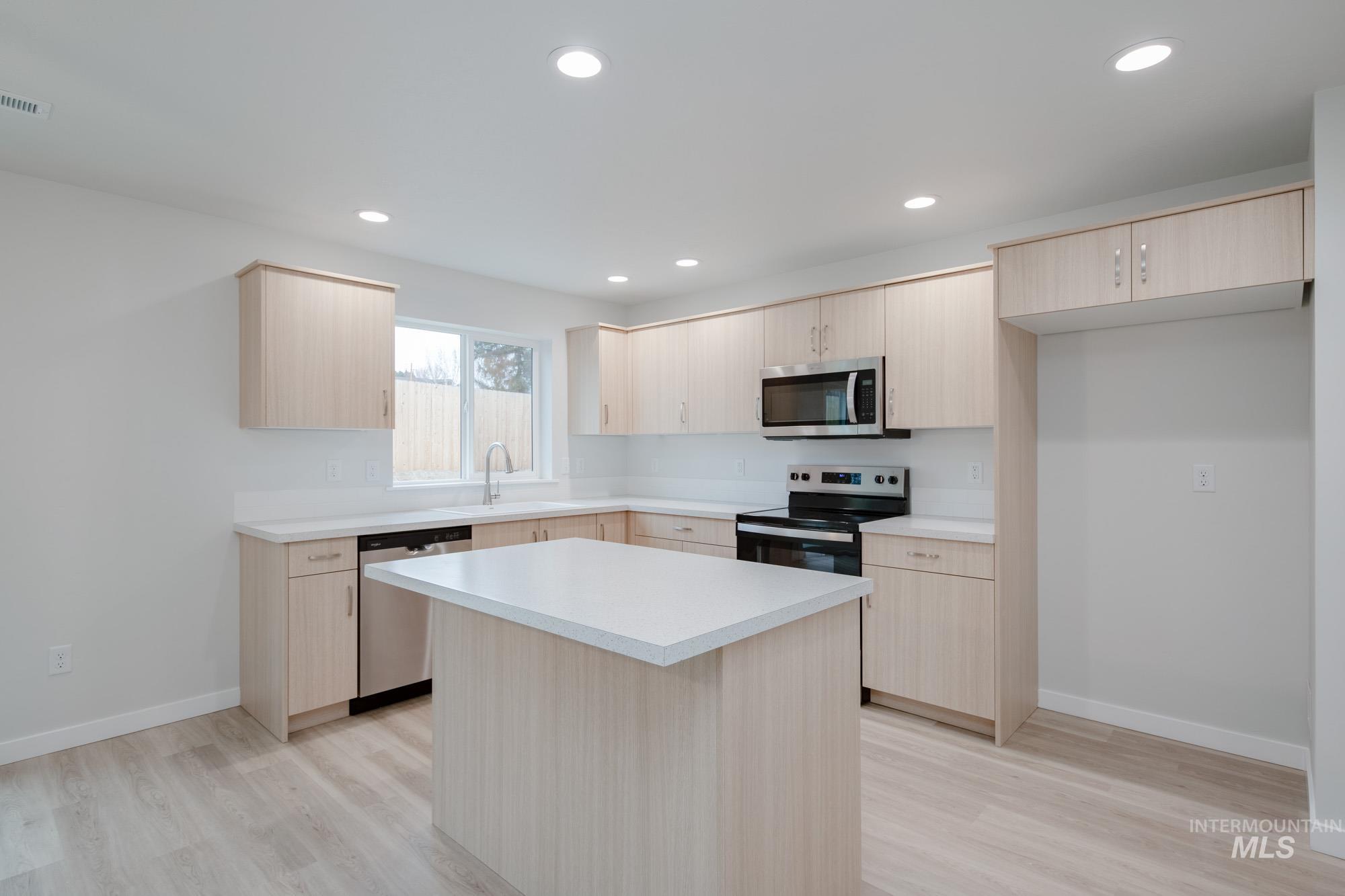1472 Long Pond Street Middleton, ID 83644 - Photo 3 of 21 Kitchen featuring light brown cabinets, light countertops, stainless steel appliances, a kitchen island, and light wood finished floors