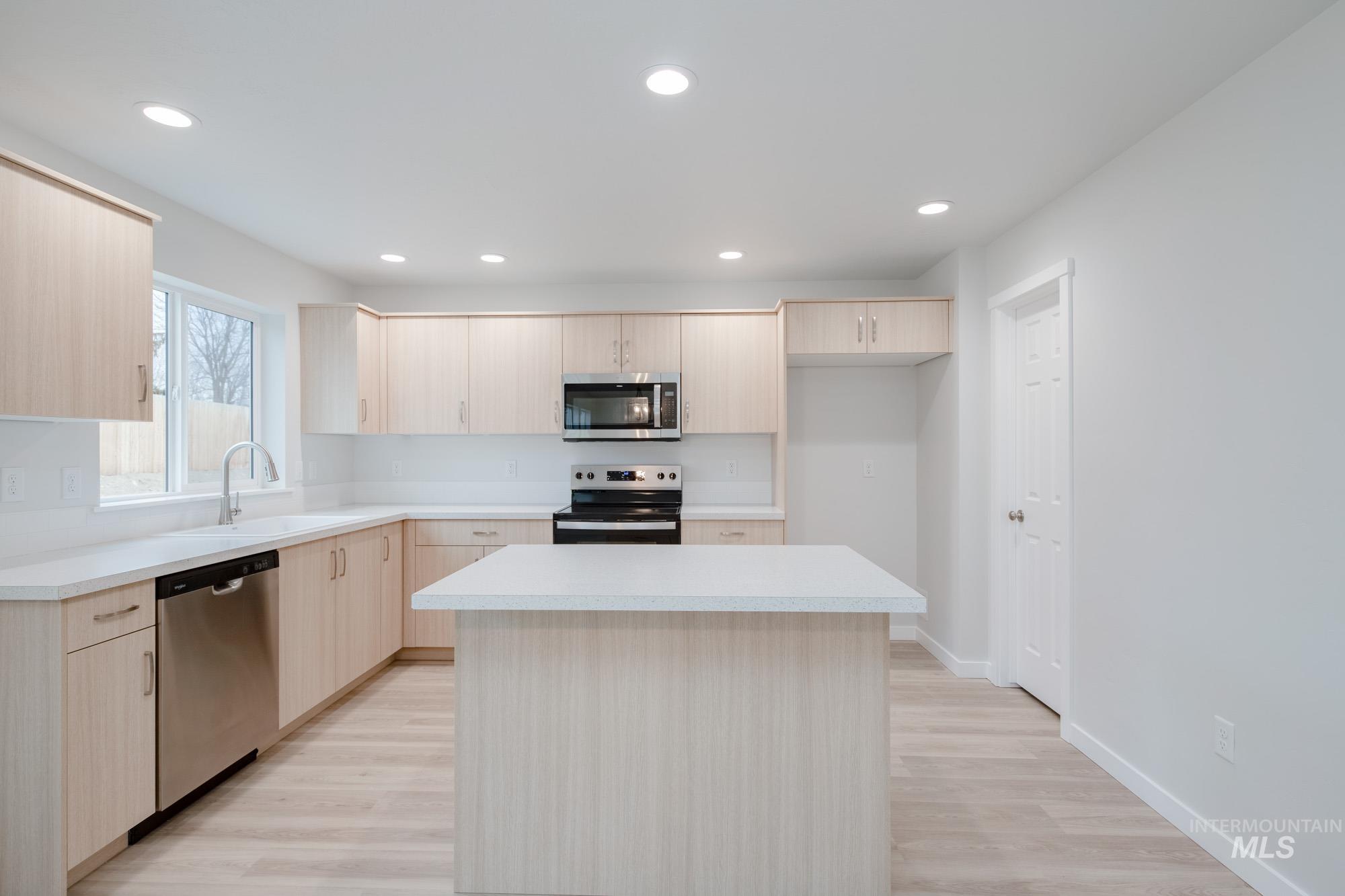 1472 Long Pond Street Middleton, ID 83644 - Photo 4 of 21 Kitchen with light brown cabinets, light countertops, light wood finished floors, appliances with stainless steel finishes, and recessed lighting
