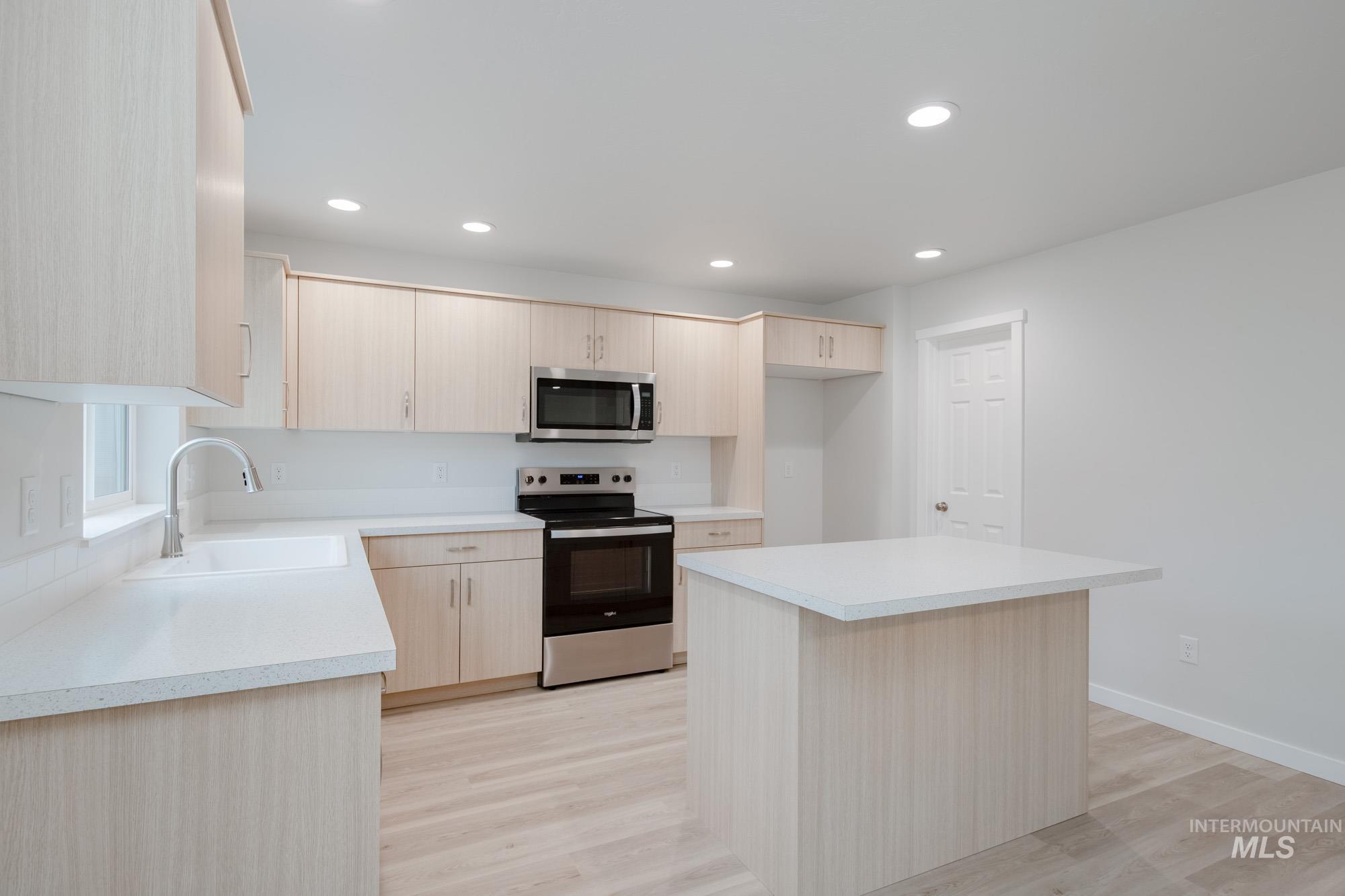 1472 Long Pond Street Middleton, ID 83644 - Photo 5 of 21 Kitchen featuring light brown cabinets, stainless steel appliances, light countertops, light wood finished floors, and a center island