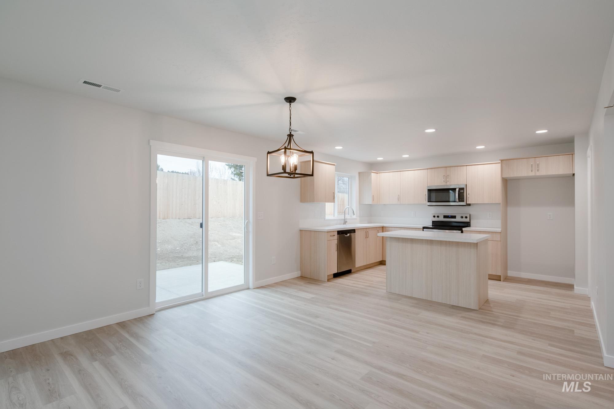 1472 Long Pond Street Middleton, ID 83644 - Photo 7 of 21 Kitchen with light countertops, stainless steel appliances, a kitchen island, light brown cabinets, and pendant lighting