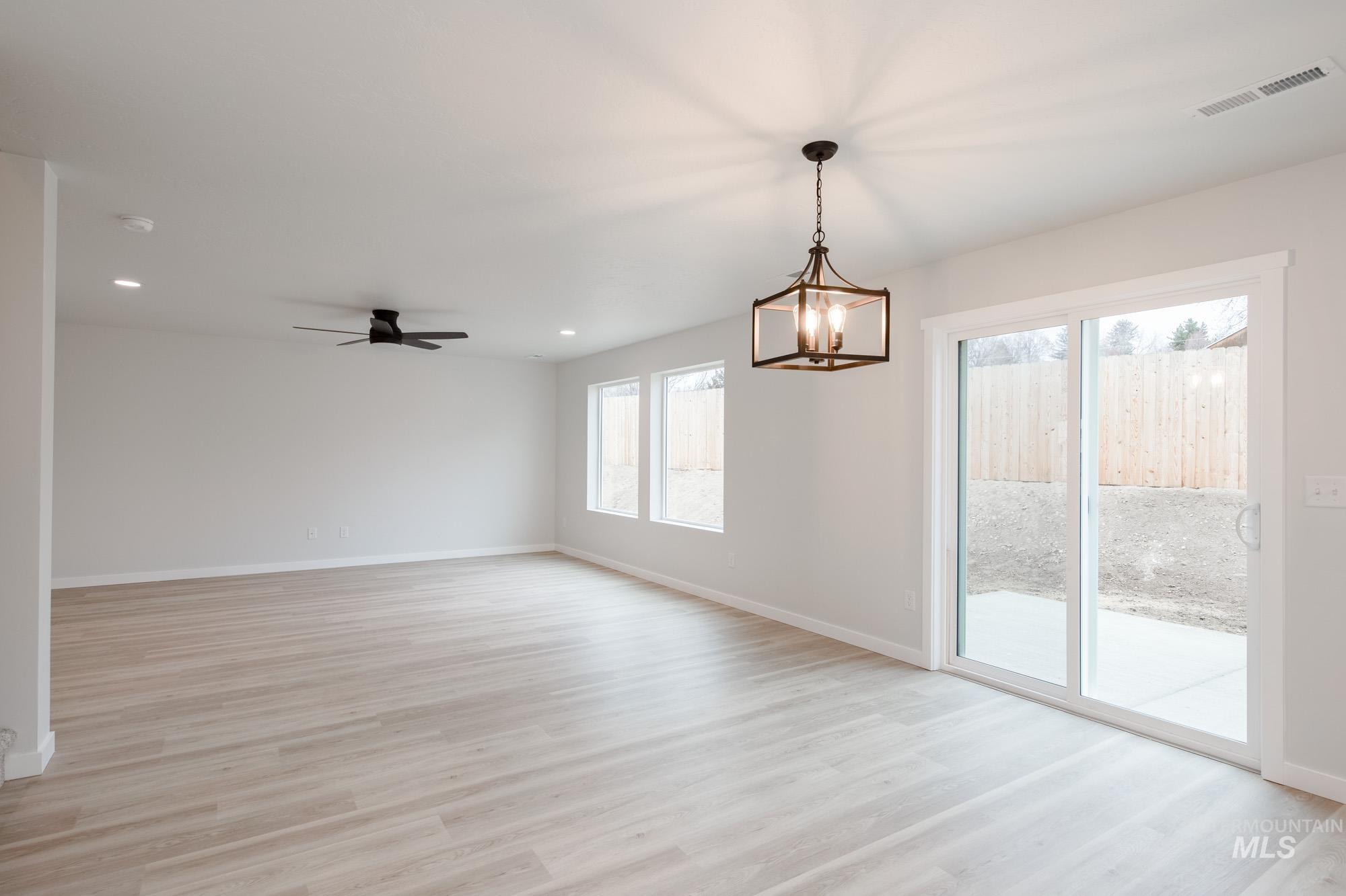 1472 Long Pond Street Middleton, ID 83644 - Photo 8 of 21 Unfurnished room featuring a chandelier, light wood-style floors, recessed lighting, and a ceiling fan